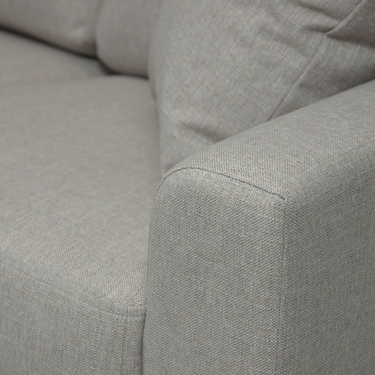 Lähikuva sohvan käsinojasta, joka on verhoiltu beigellä kankaalla nimeltään Hygge 10