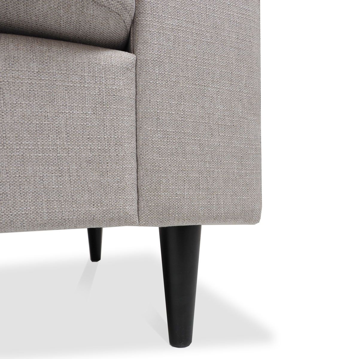 Lähikuva Napue sohvan jalasta. Jalka on musta ja pyöreä ja se on kiinnitetty beigen väriseen sohvaan