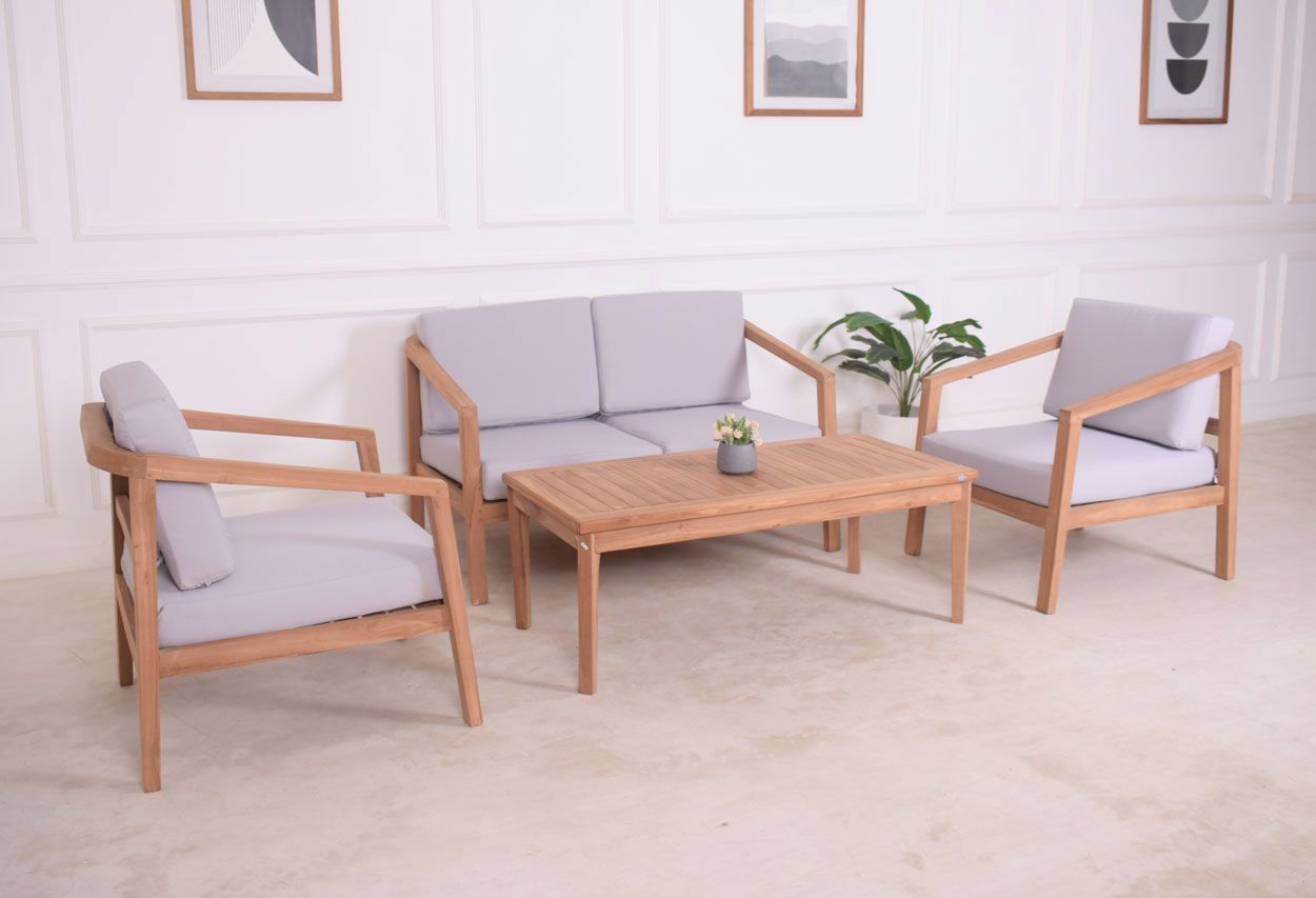 Tiikkinen sohvaryhmä sohvapöydällä. 2-istuttava sohva ja kaksi lepotuolia pehmusteineen.