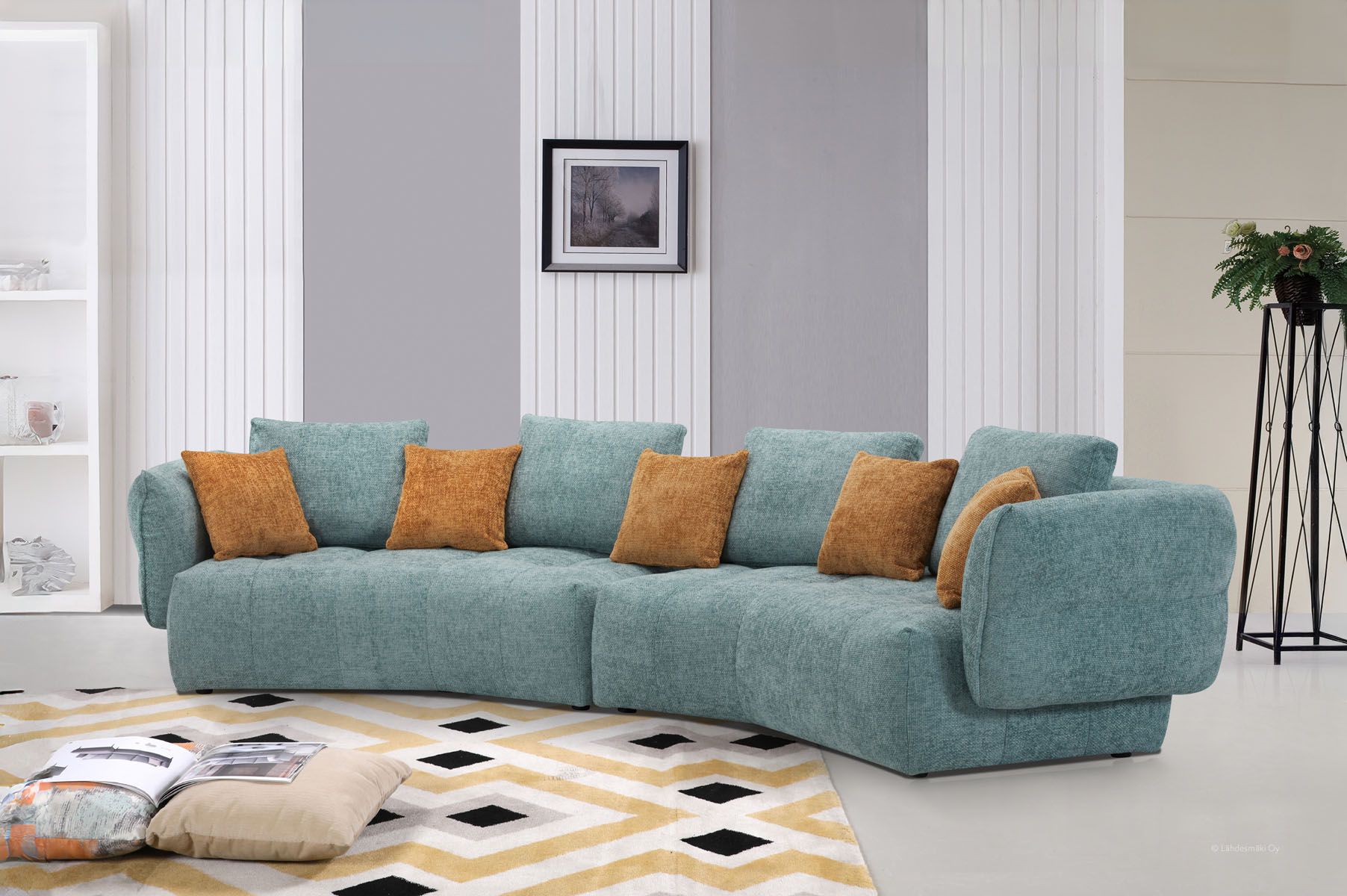 Kaareva turkoosi iso sohva, jossa on oranssit tyynyt