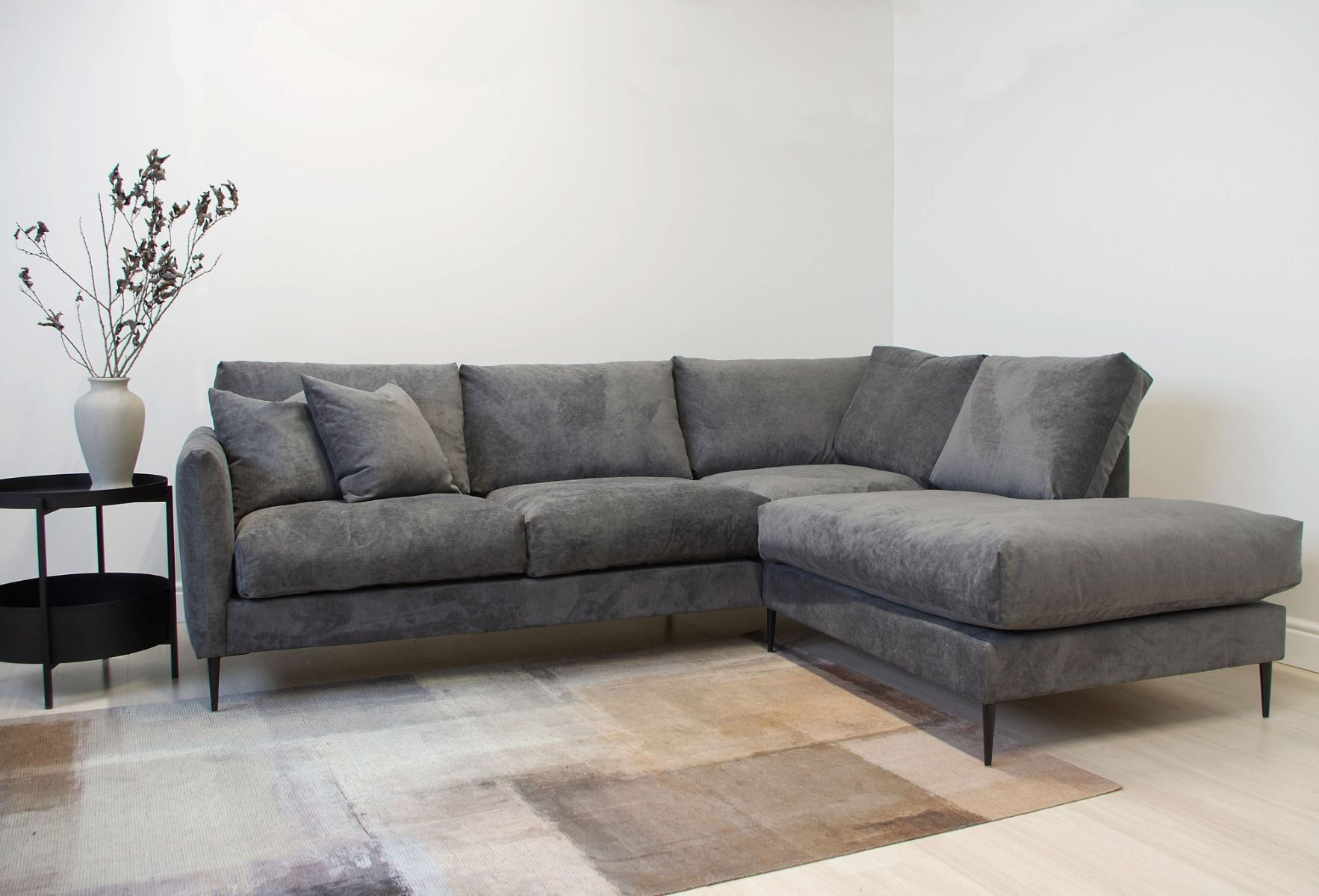 Tummanharmaa kulmasohva höyhentyynyillä