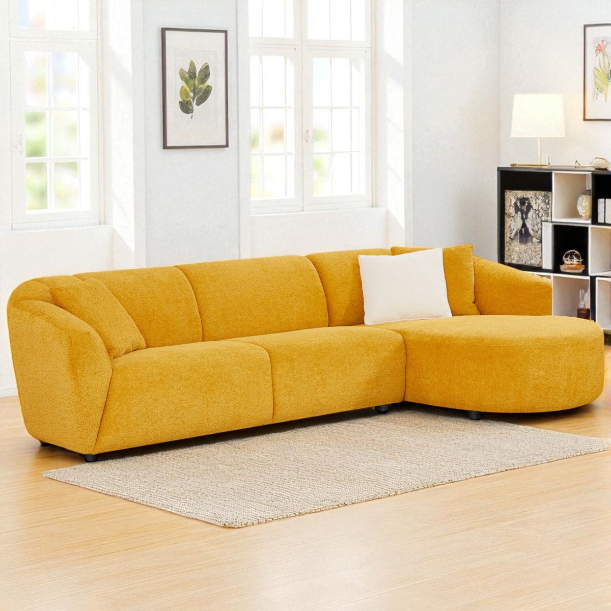 Keltainen pyöreä divaanisohva kuvattuna vaaleassa olohuoneessa