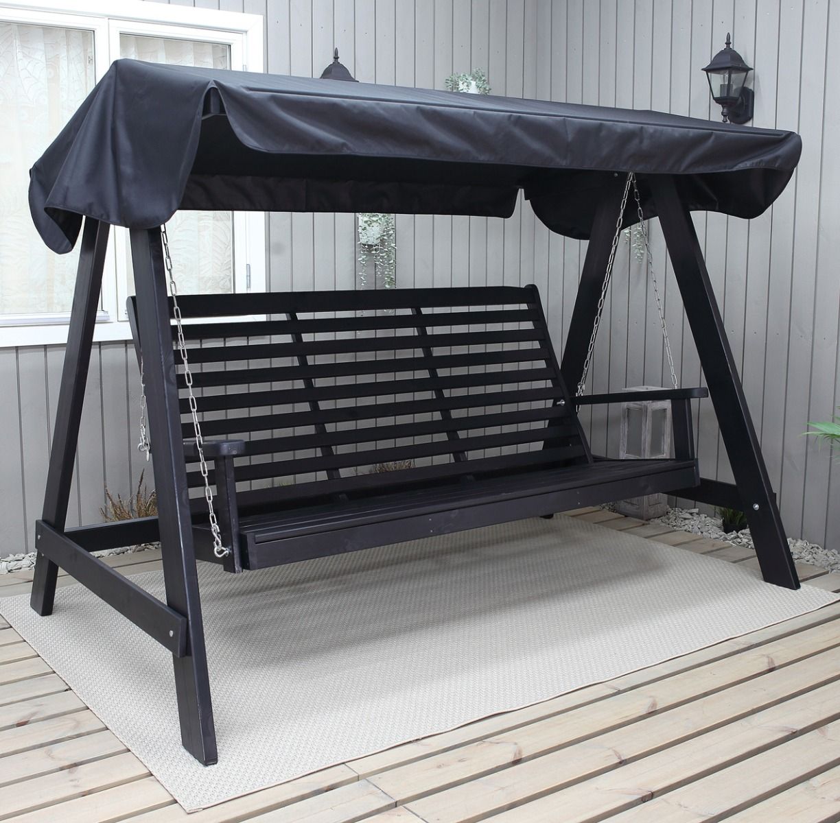 Musta puutarhakeinu tai pihakeinu kuvattuna terassilla