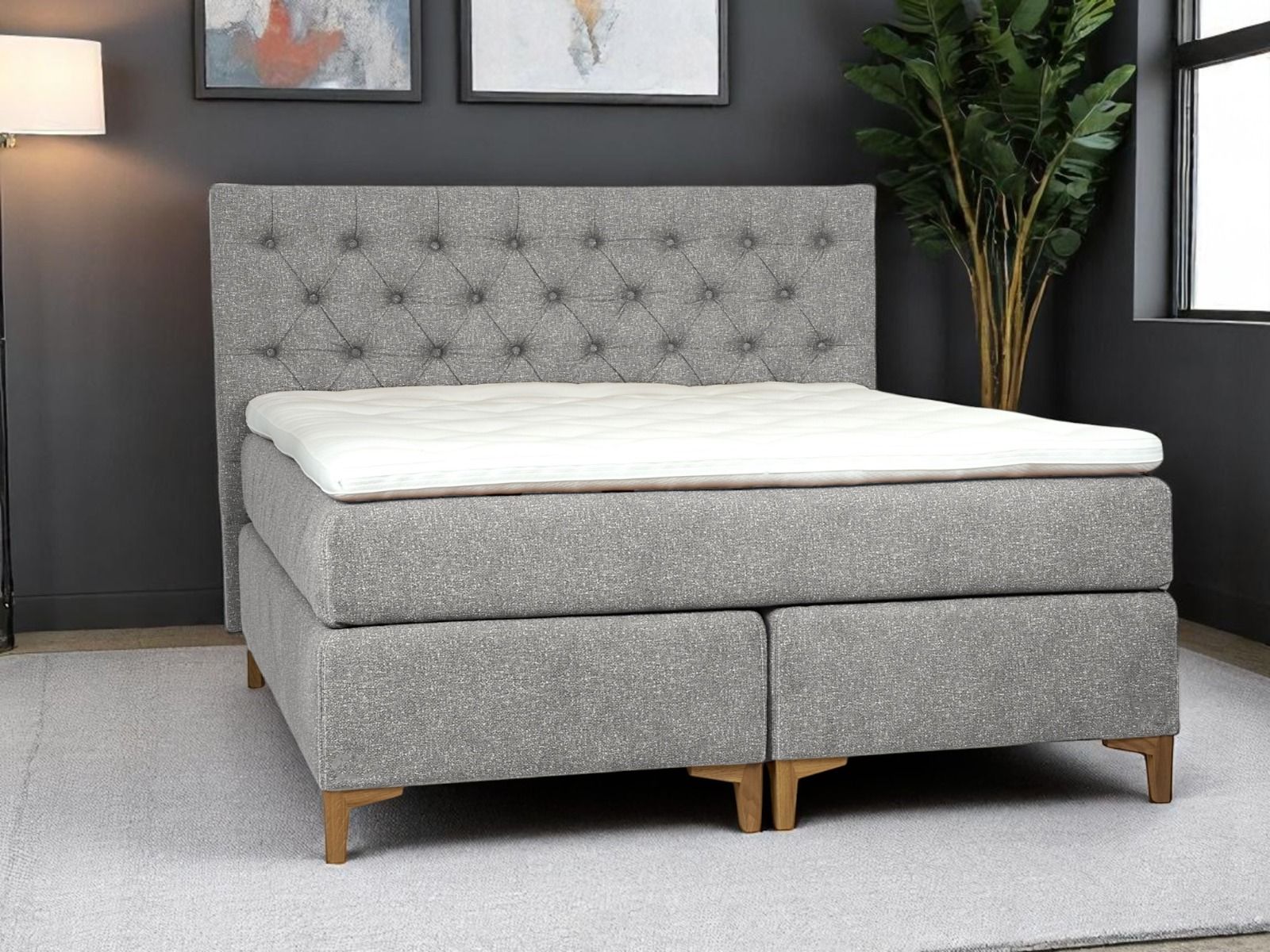 Pramia jenkkisänky harmaa ja nappi sängynpääty kuvattuna tummassa makuuhuoneessa