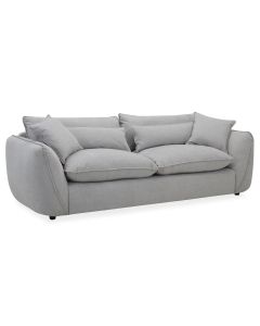 Muhkea 3,5-istuttava sohva harmaalla kangasverhoilulla. Muhkeat irtotyynyt sekä koristetyynyt.